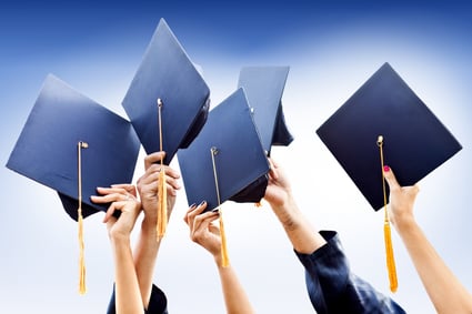 Group of people throwing graduation hats in the air